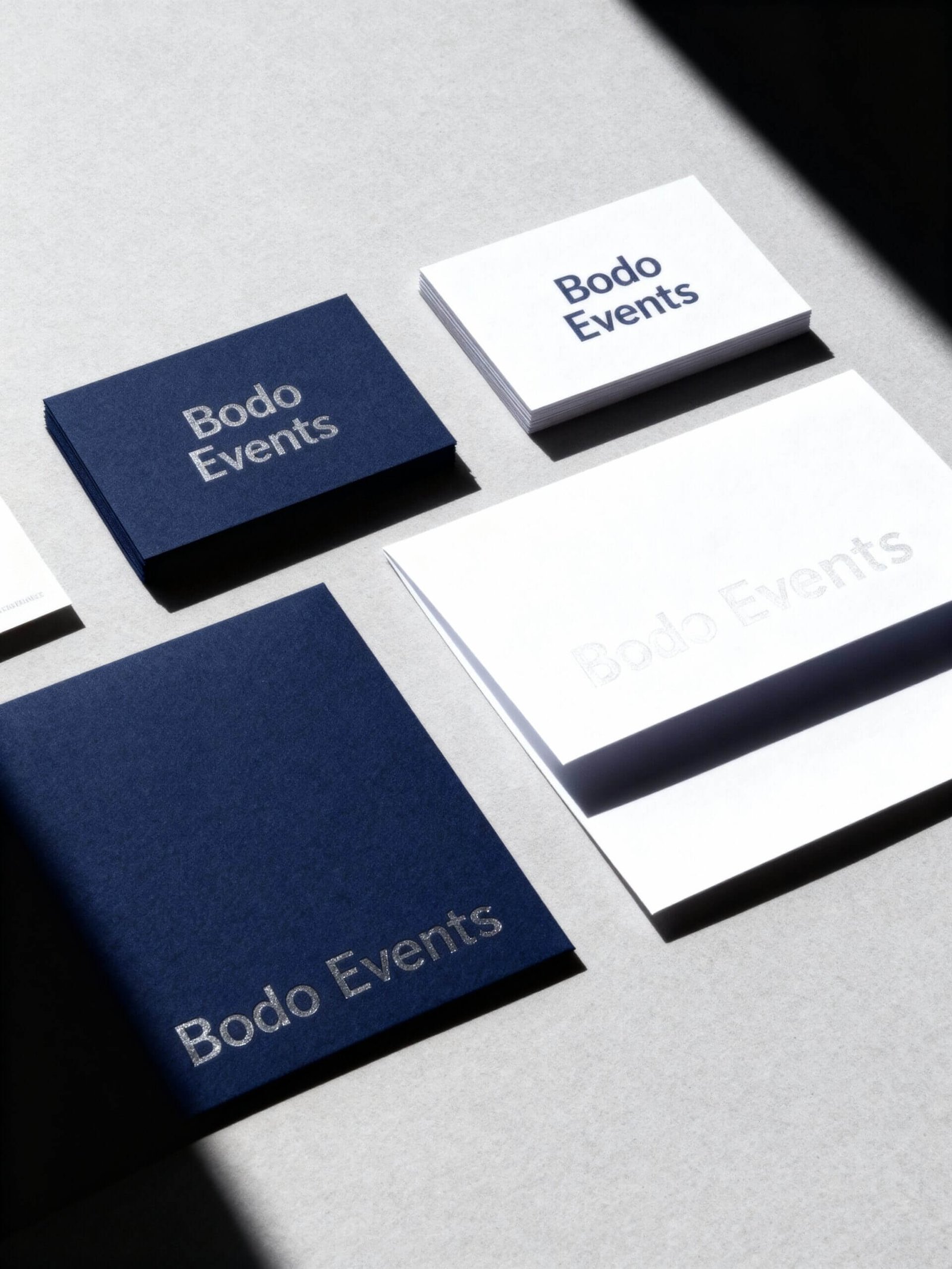 http://Visuelle%20Darstellung%20von%20Bodo%20Events%20Branding,%20einschließlich%20blauer%20und%20weißer%20Visitenkarten%20sowie%20einem%20Notizbuch%20mit%20dem%20Logo%20Bodo%20Events%20in%20eleganter%20Schrift%20auf%20einem%20hellen%20Hintergrund.