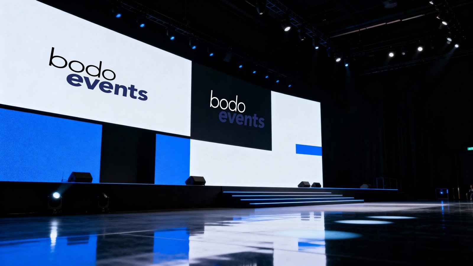 http://Bühne%20bei%20einer%20Veranstaltung%20mit%20dem%20Logo%20von%20Bodo%20Events%20auf%20großen%20Bildschirmen,%20umgeben%20von%20blauer%20Beleuchtung%20und%20einem%20glänzenden%20Boden.