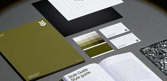 Stilvolle Präsentation eines Markenidentität-Pakets mit einem Style Guide, Visitenkarten, Farbpaletten und einem Logo-Design in verschiedenen Grüntönen auf einem neutralen Hintergrund.